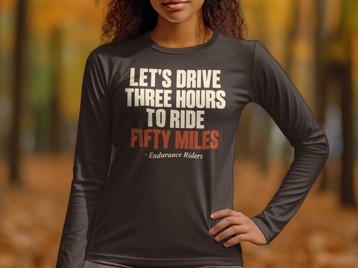A person wearing a dark grey long-sleeve shirt with the text "LET'S DRIVE THREE HOURS TO RIDE FIFTY MILES - Endurance Riders".