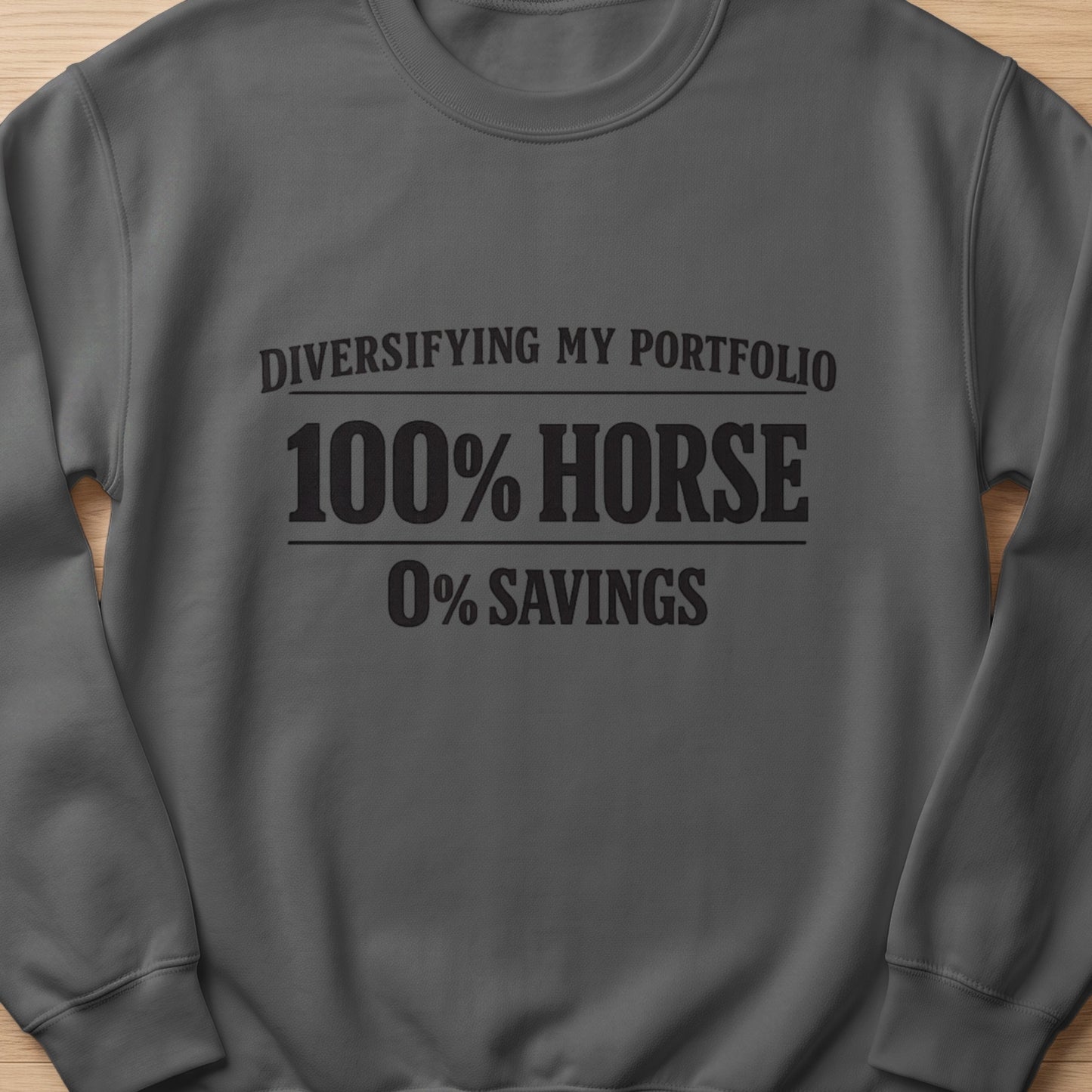 Dark gray sweatshirt with text "Diversifying my portfolio 100% horse 0% savings".