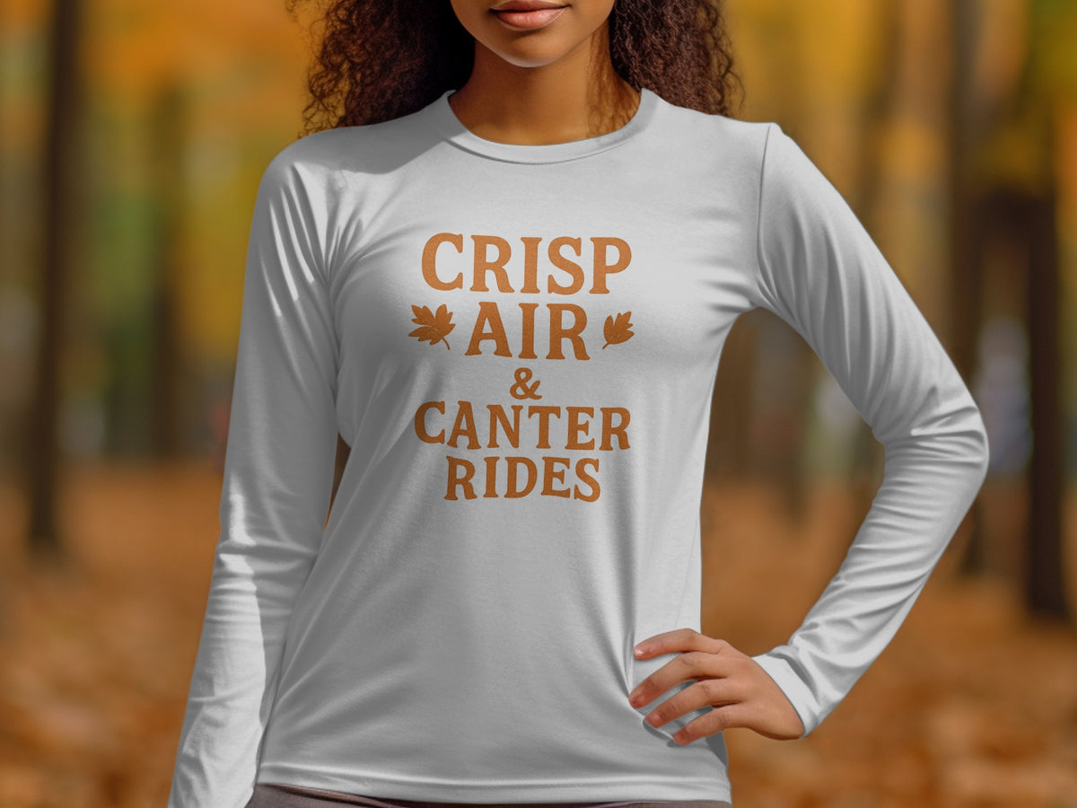 White long-sleeve shirt with text "CRISP AIR & CANTER RIDES" and leaf graphics.