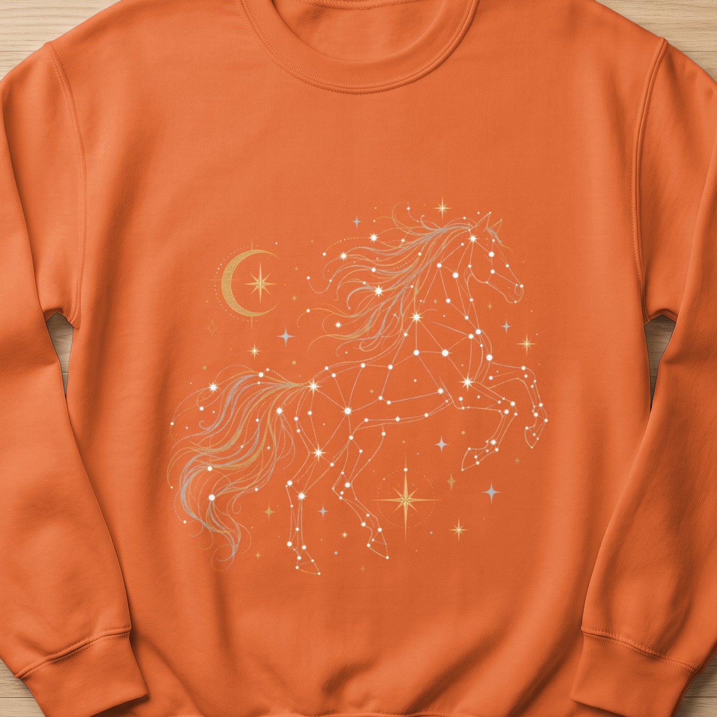 Orange sweatshirt with a white and gold constellation horse and crescent moon graphic.