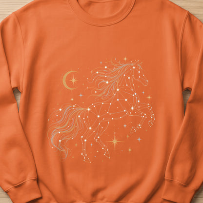 Orange sweatshirt with a white and gold constellation horse and crescent moon graphic.