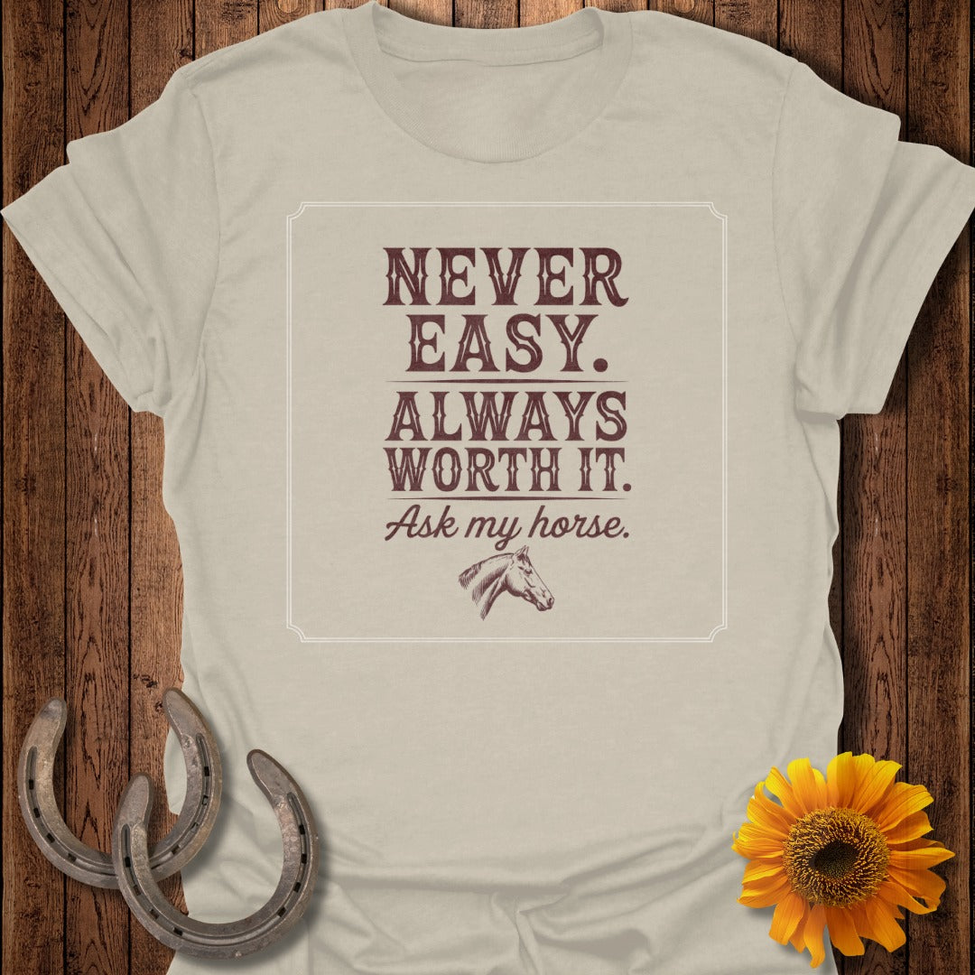 Light tan t-shirt with "Never Easy. Always Worth It. Ask my horse." text and horse graphic.