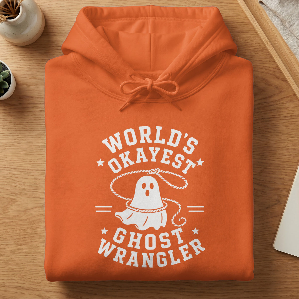 Orange hoodie with white text and a ghost graphic, reading "World's Okayest Ghost Wrangler".