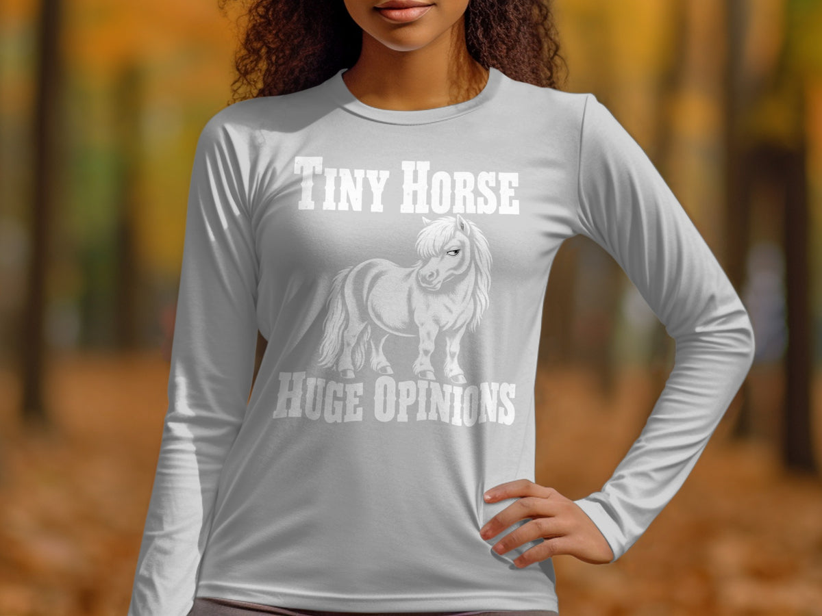 A person wearing a grey long-sleeve shirt with a graphic of a pony and the text "Tiny Horse Huge Opinions".