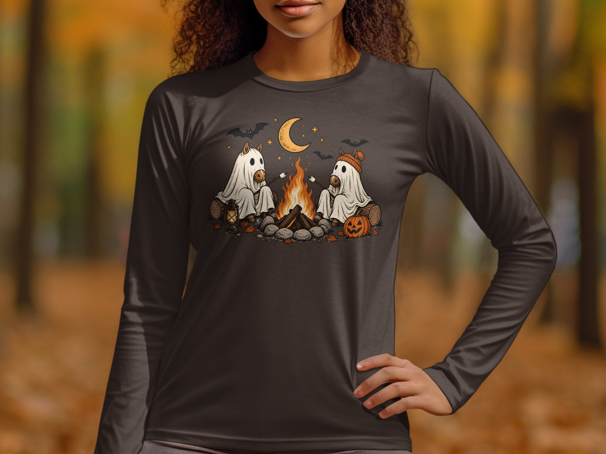Two horses in ghost costumes roast marshmallows by a campfire under a crescent moon.
