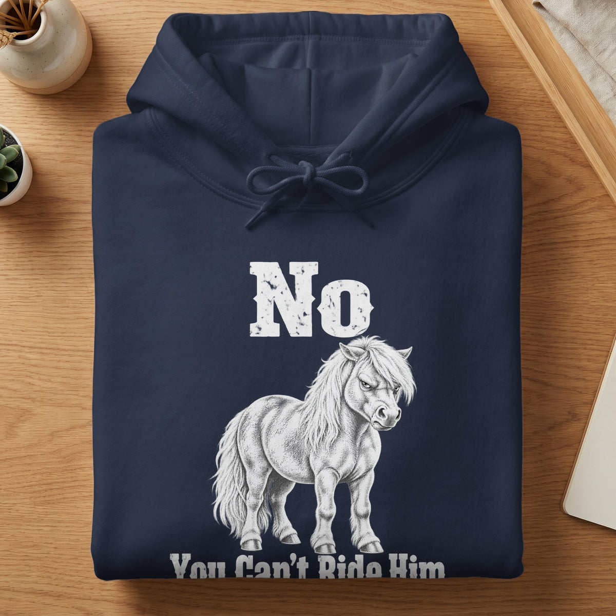 A folded navy blue hoodie featuring a distressed white graphic of an angry pony with text reading "No You Can't Ride Him".