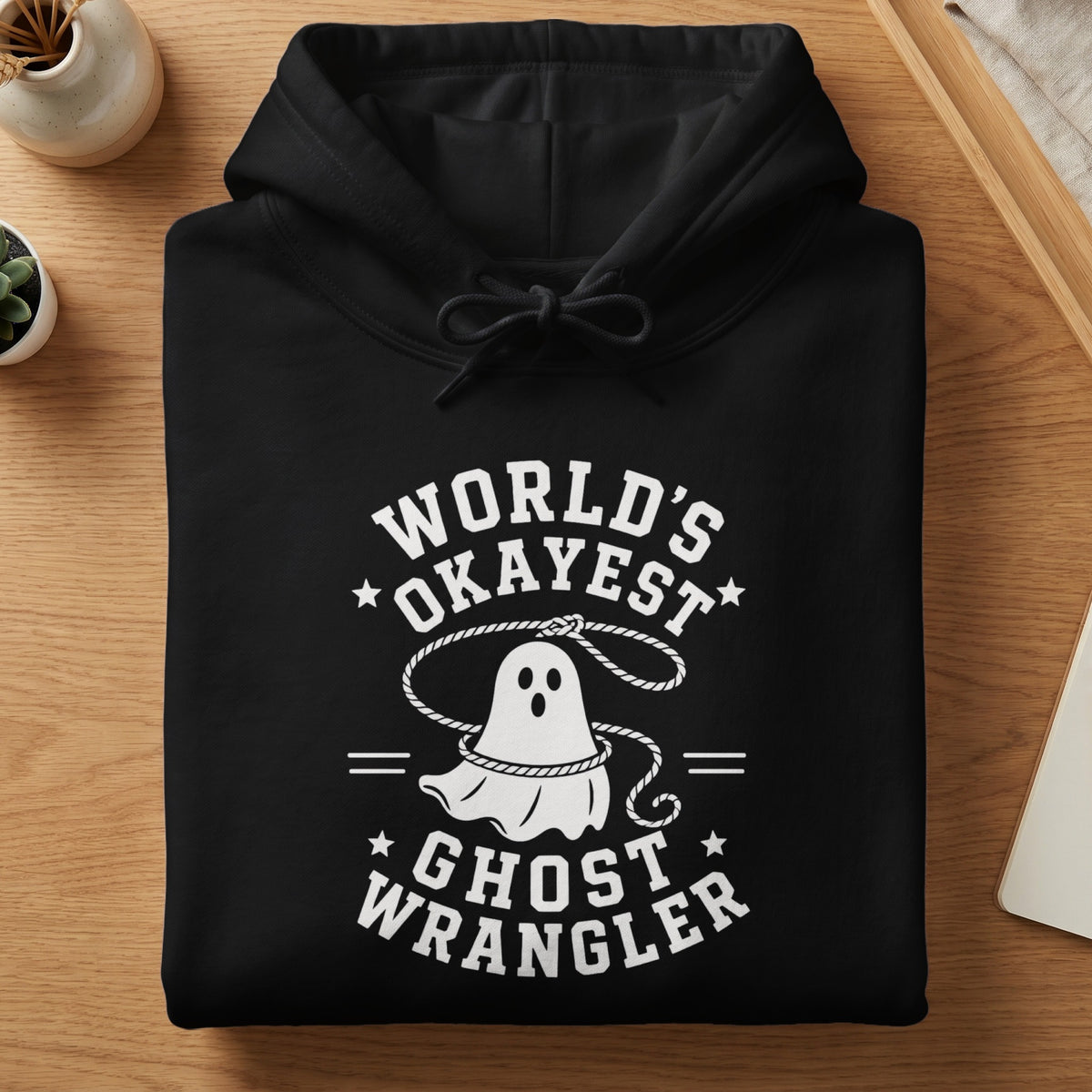 Black hoodie with white text "World's Okayest Ghost Wrangler" and ghost graphic.