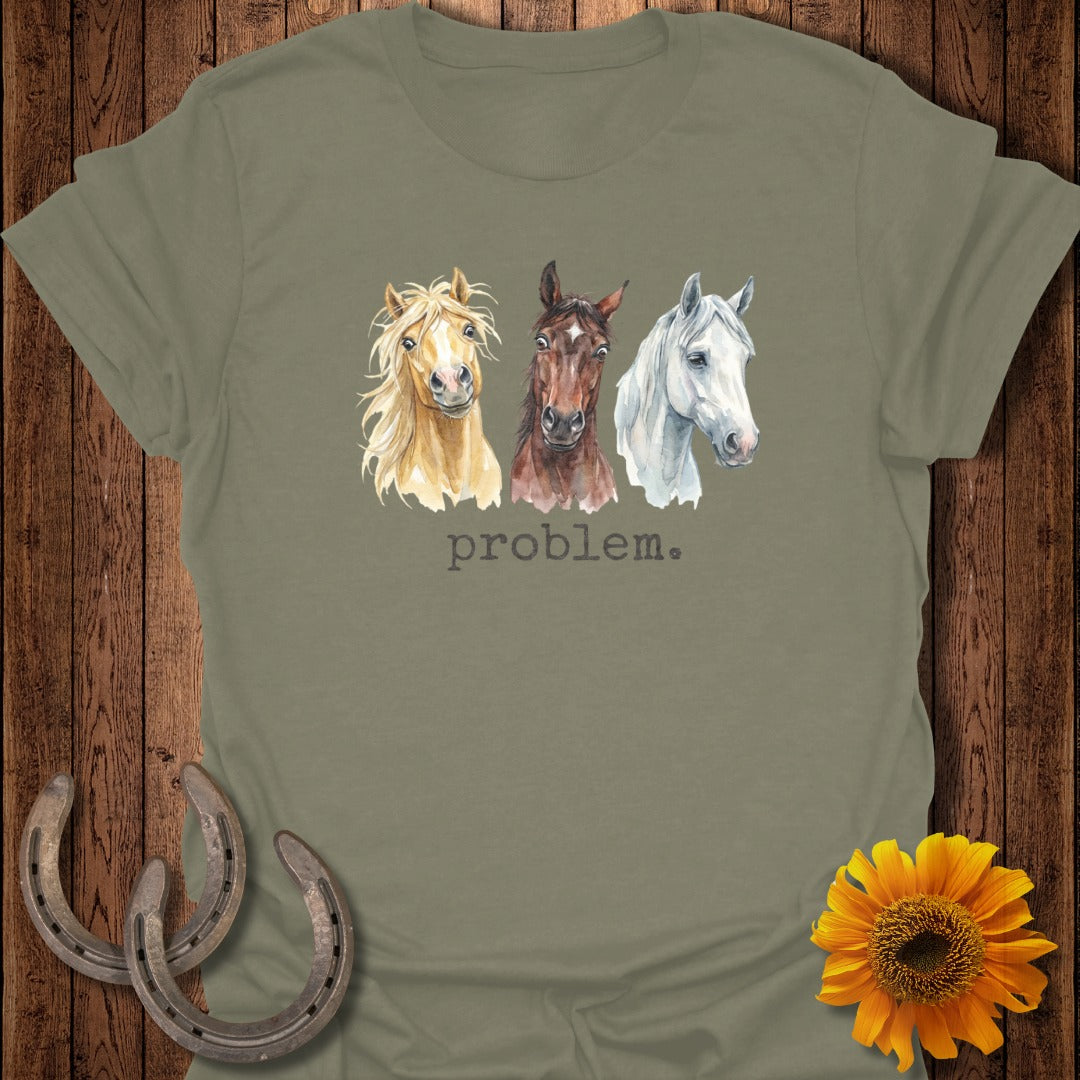 Three watercolor horses on a light green t-shirt with "problem." text.