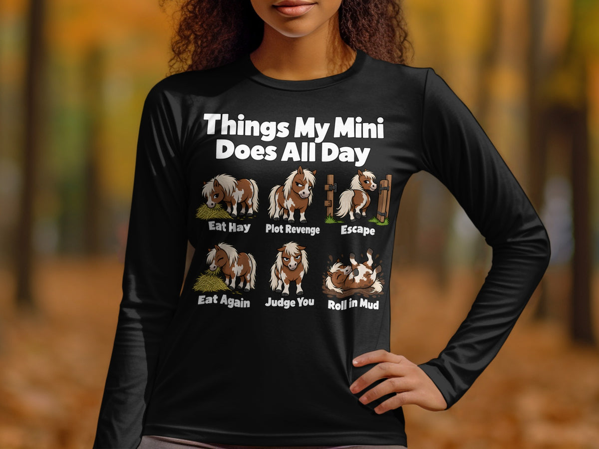 A person wearing a black long-sleeve shirt with a humorous pony design and text.
