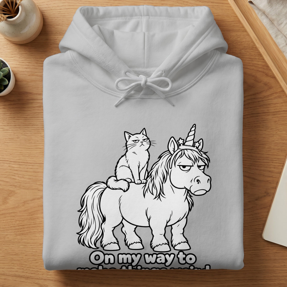 White hoodie with graphic of grumpy cat riding a unicorn, text "On my way to".