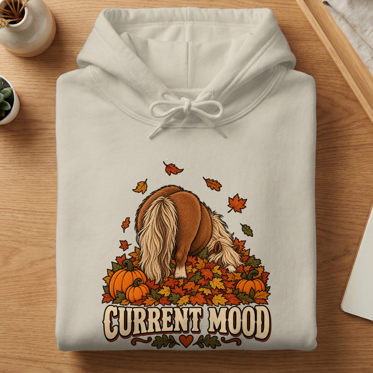 Cream hoodie with illustration of a horse in leaves and pumpkins, text reads "Current Mood".