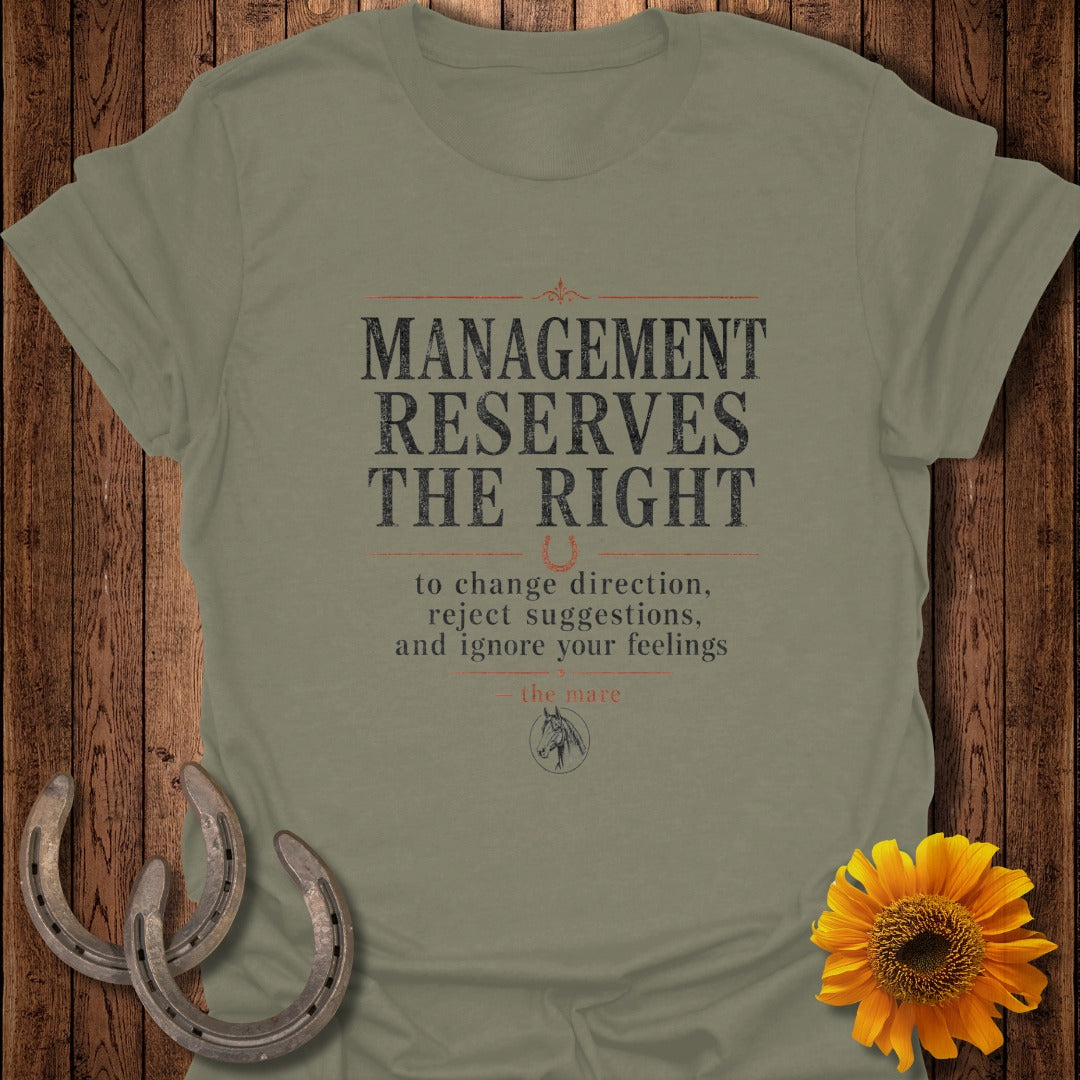 Olive green t-shirt with "Management Reserves the Right to change direction, reject suggestions, and ignore your feelings - the mare" text.