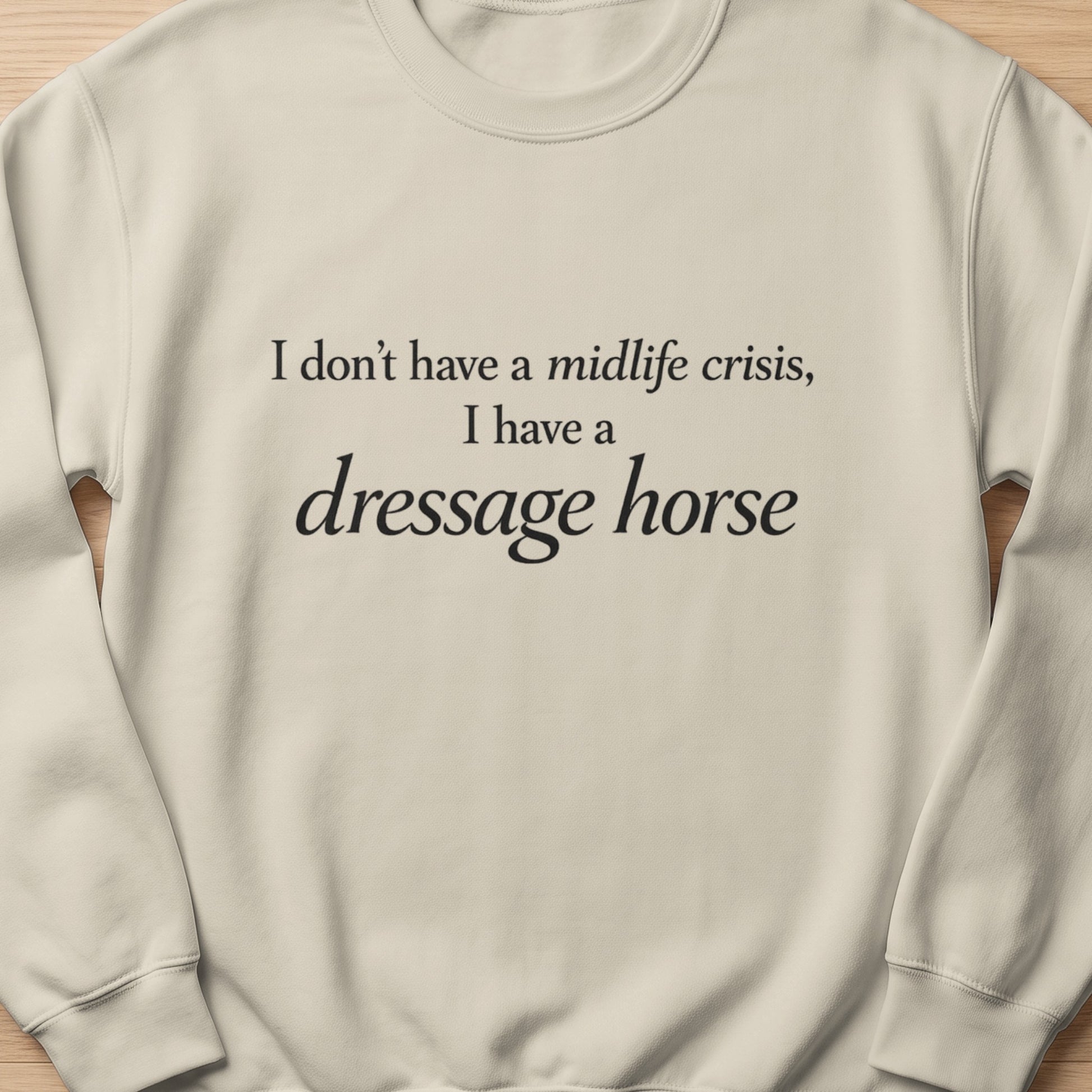 Light beige crewneck sweatshirt with black text stating "I don't have a midlife crisis, I have a dressage horse".