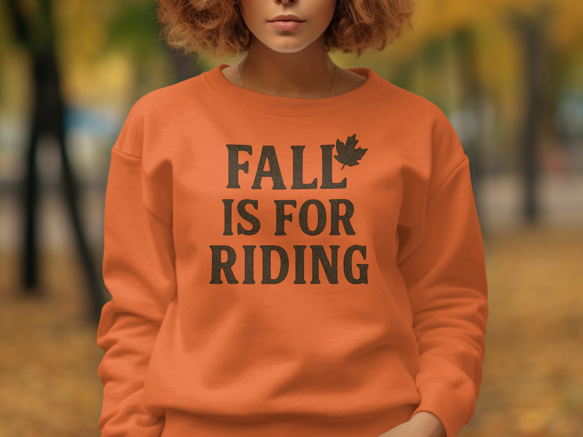 Orange sweatshirt with black text "FALL IS FOR RIDING" and a maple leaf.