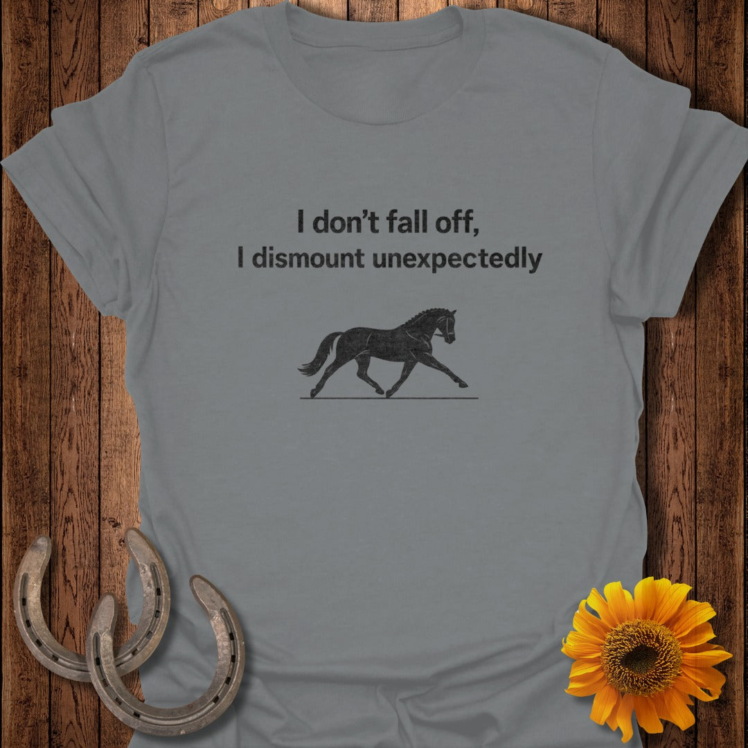 Grey t-shirt with text "I don't fall off, I dismount unexpectedly" and a horse illustration.