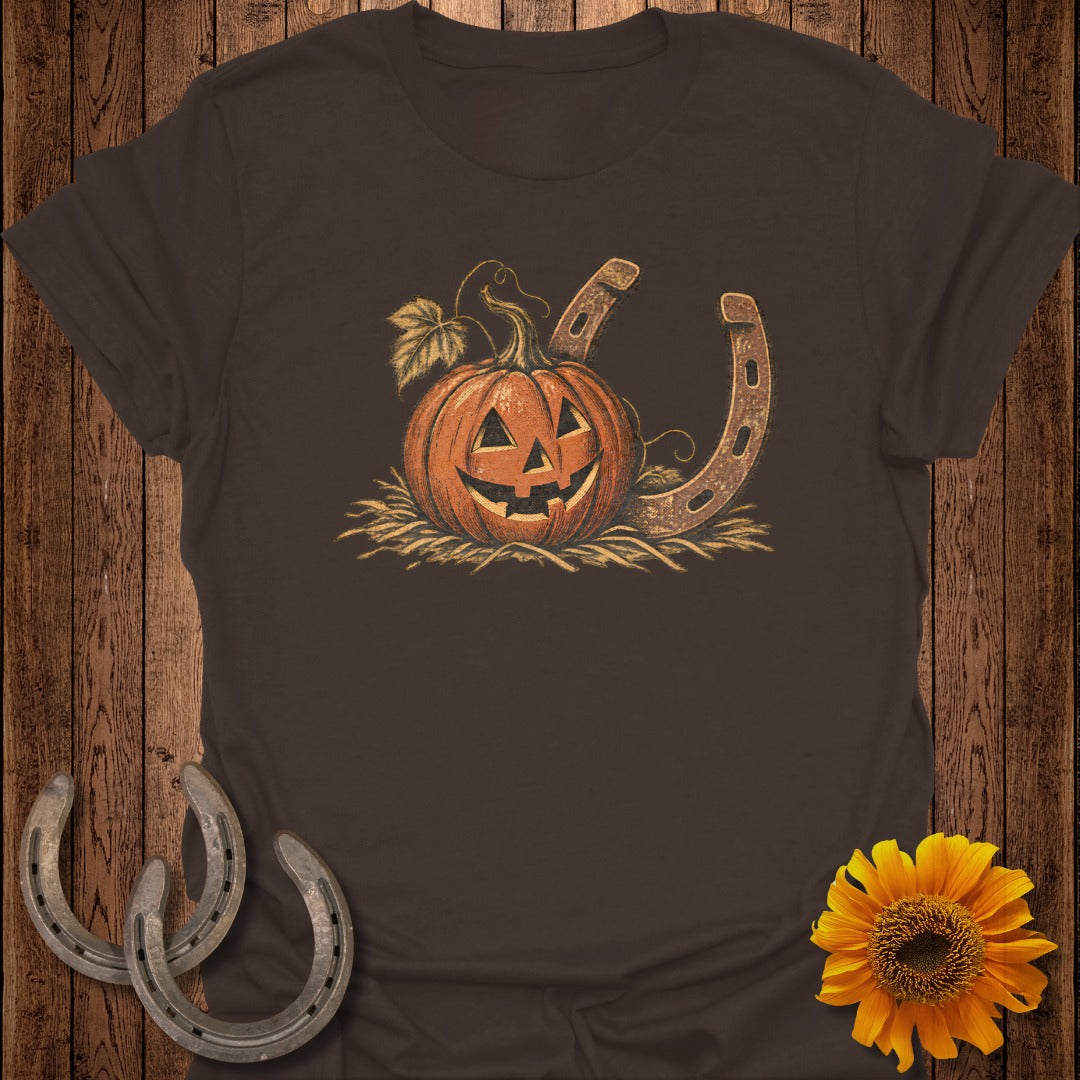 Jack-o'-lantern with horseshoe and straw on a brown t-shirt.