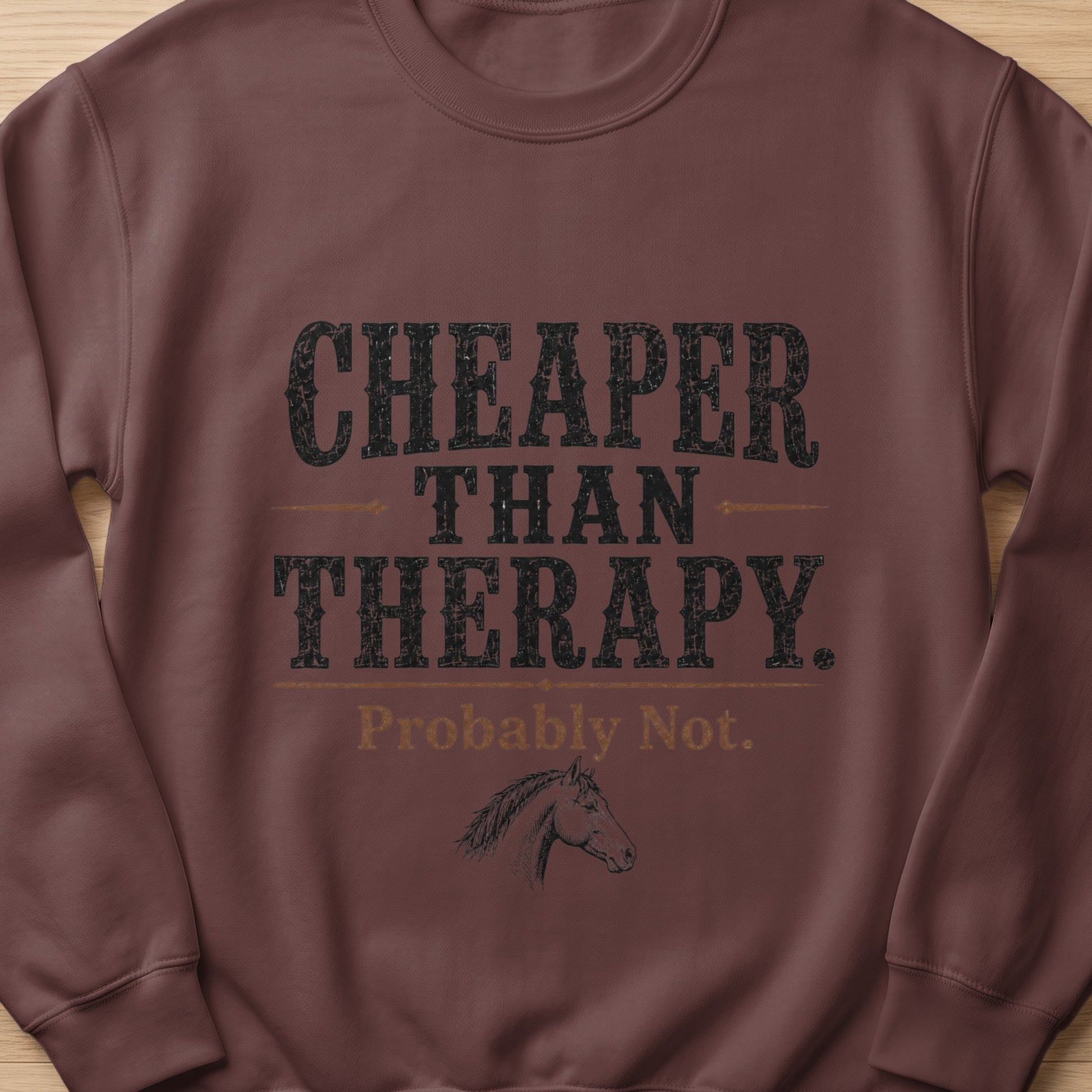 Brown sweatshirt with "Cheaper Than Therapy. Probably Not." text and horse graphic.