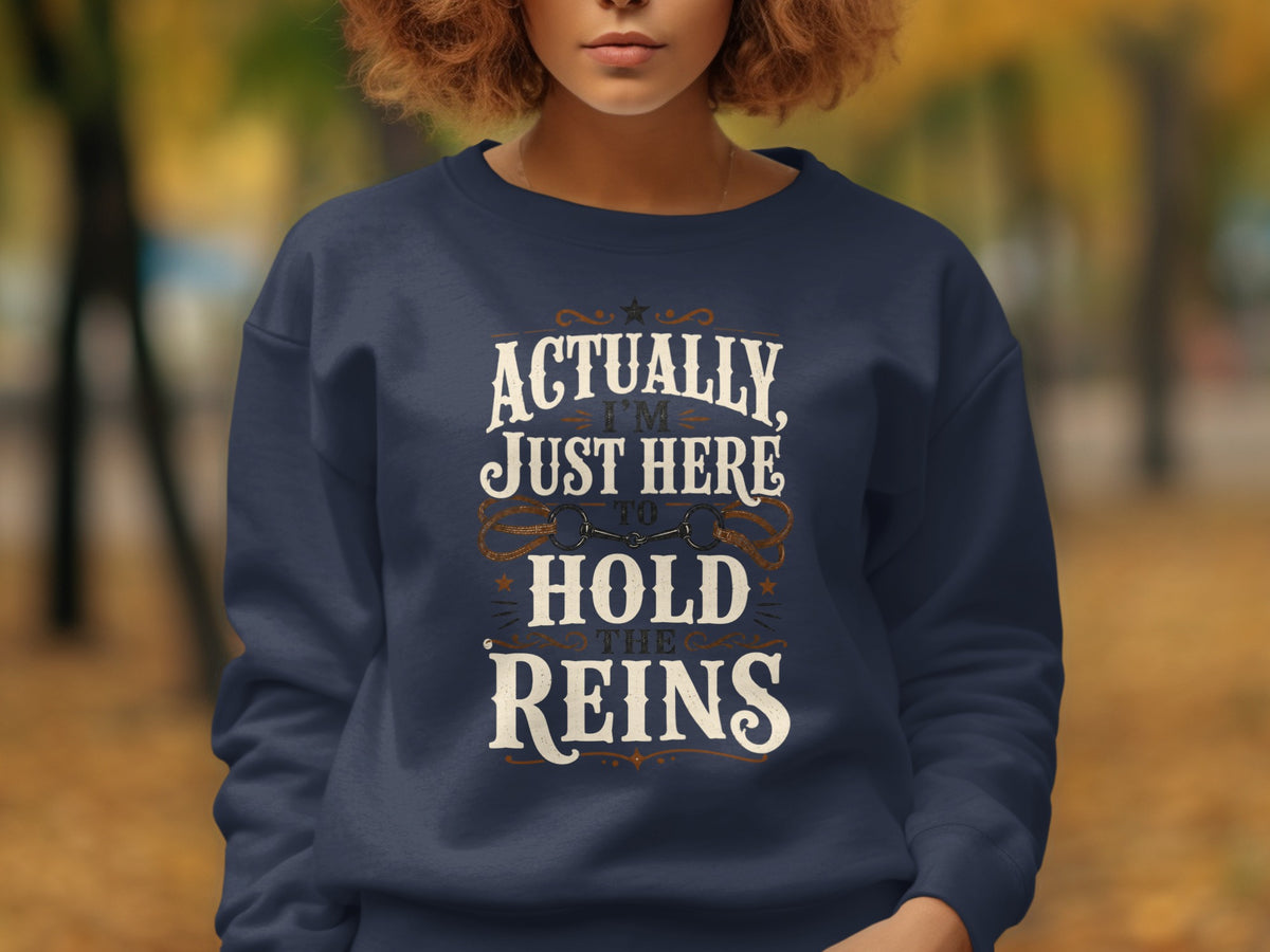 Navy sweatshirt with "Actually, I'm Just Here to Hold the Reins" and horse bit graphic.