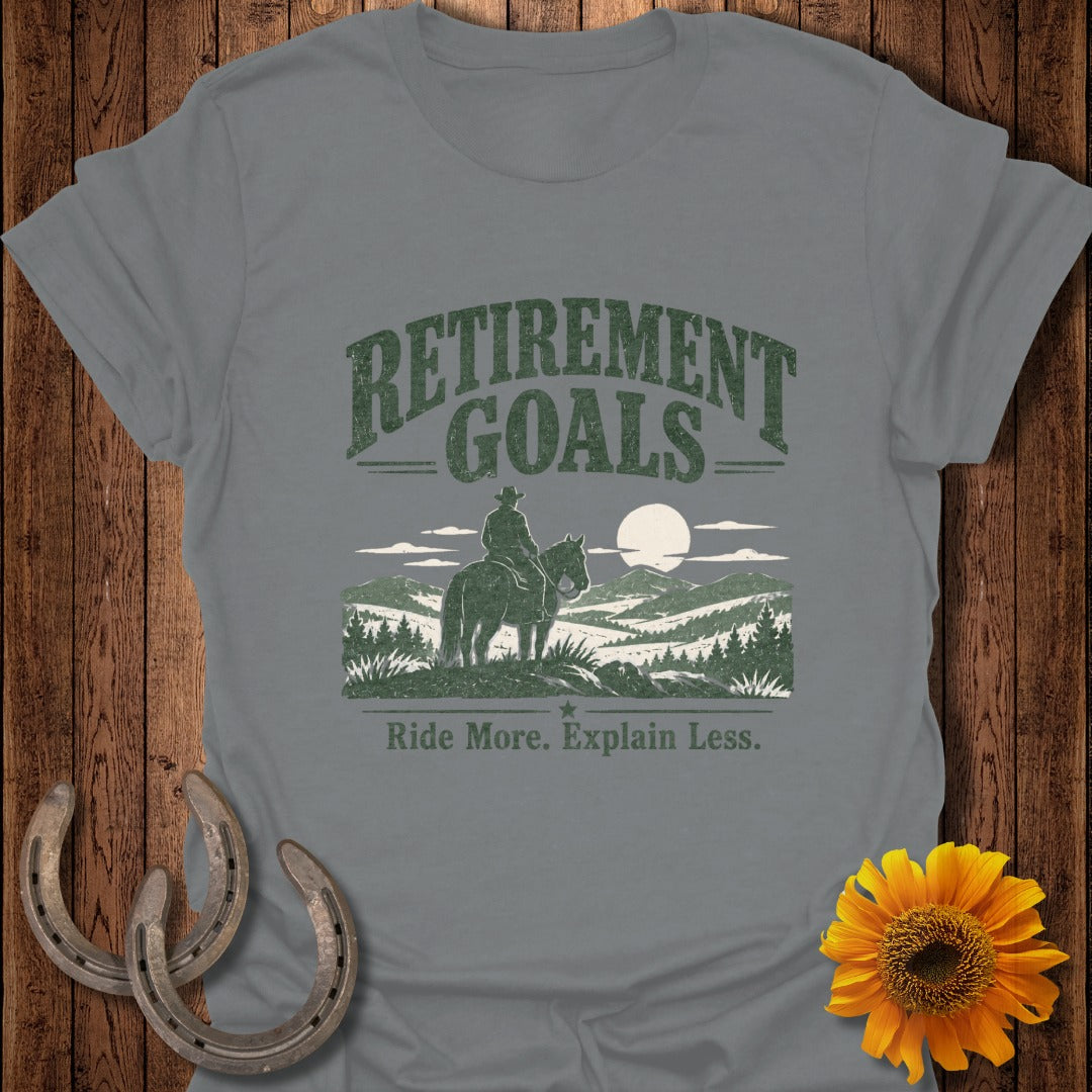 Grey t-shirt with "Retirement Goals Ride More. Explain Less." and a cowboy on horseback.