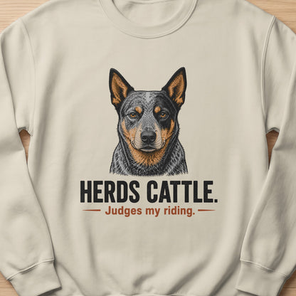 Cream sweatshirt with an Australian Cattle Dog illustration and text "HERDS CATTLE. Judges my riding."