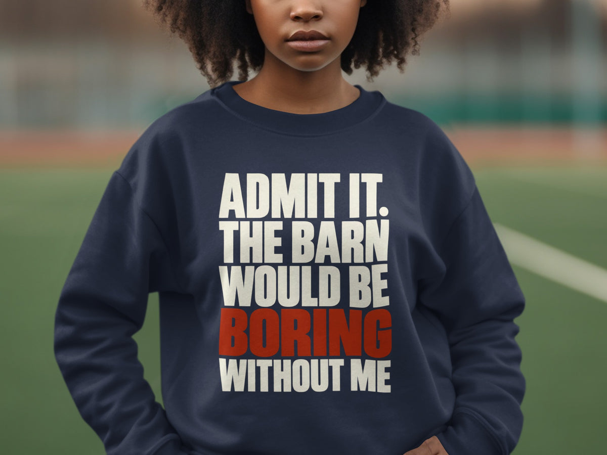 A person wearing a dark blue crewneck sweatshirt with the text ADMIT IT. THE BARN WOULD BE BORING WITHOUT ME.