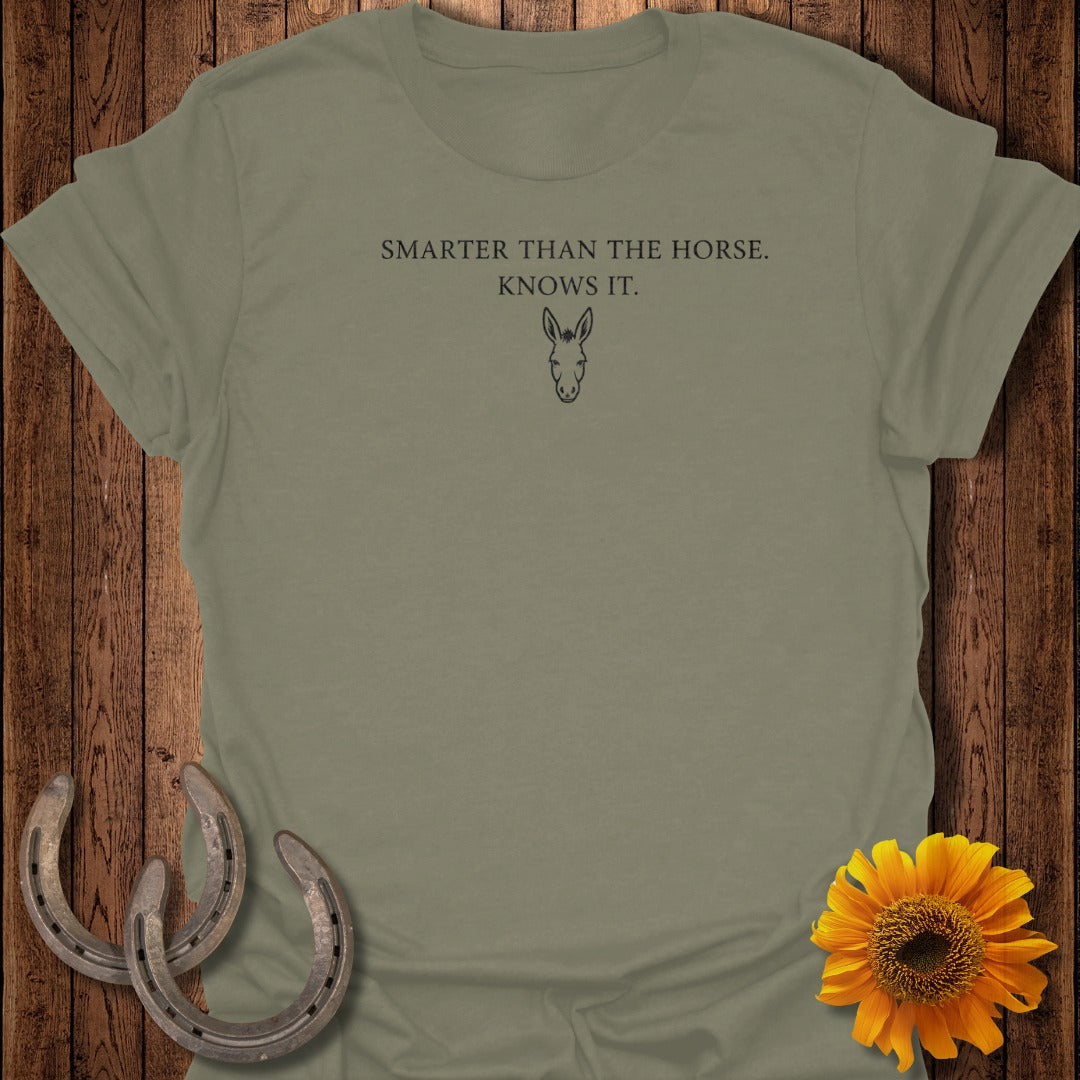 Olive green t-shirt with text "SMARTER THAN THE HORSE. KNOWS IT." and donkey graphic.