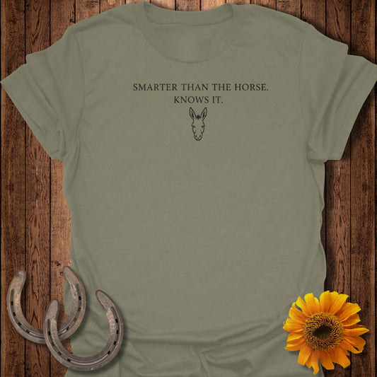 Olive green t-shirt with text "SMARTER THAN THE HORSE. KNOWS IT." and donkey graphic.