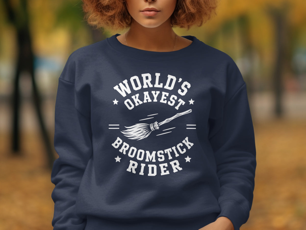Navy sweatshirt with white text "World's Okayest Broomstick Rider" and broom graphic.