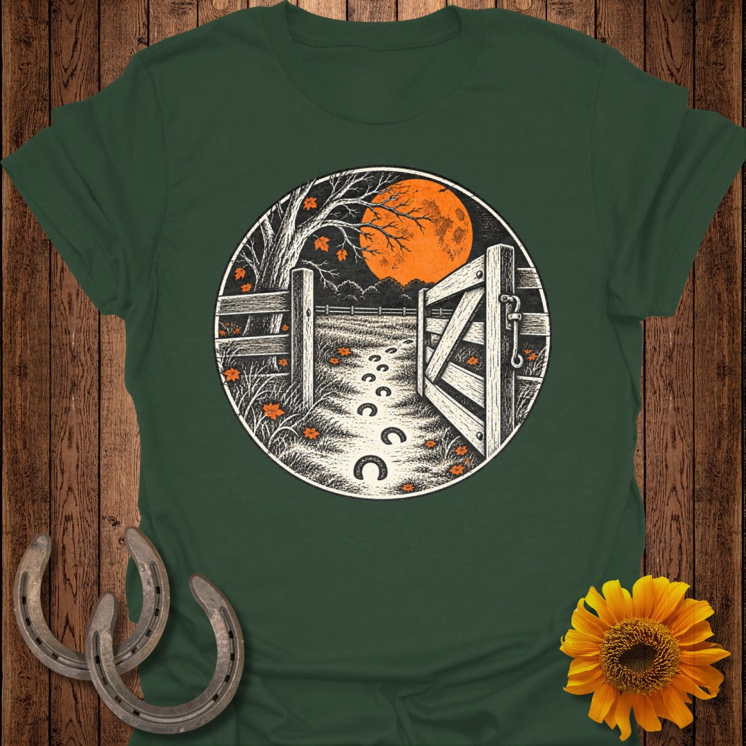 Green t-shirt with circular graphic of an open gate, moon, and horseshoe prints.