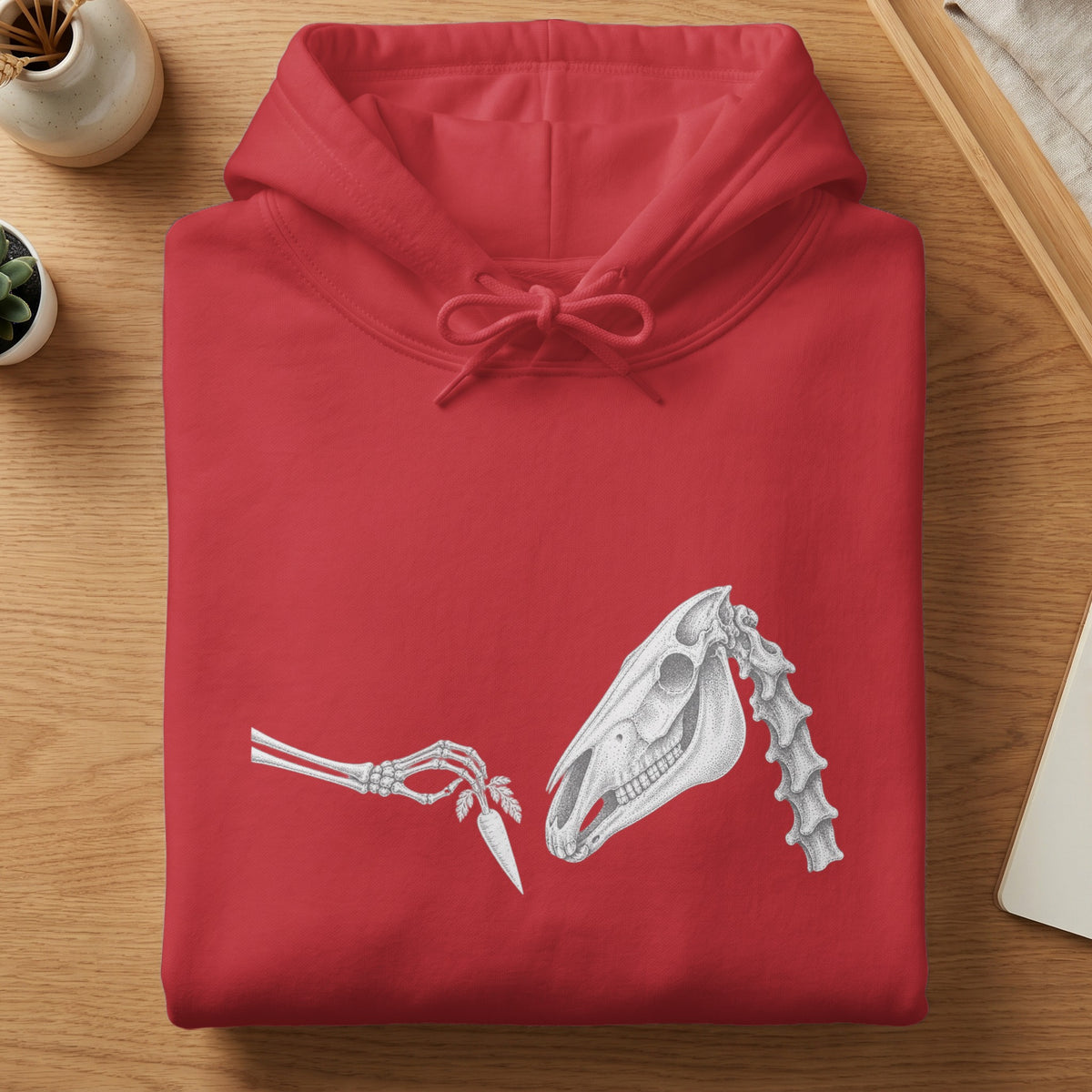 Red hoodie with a skeleton hand offering a carrot to a horse skull graphic.