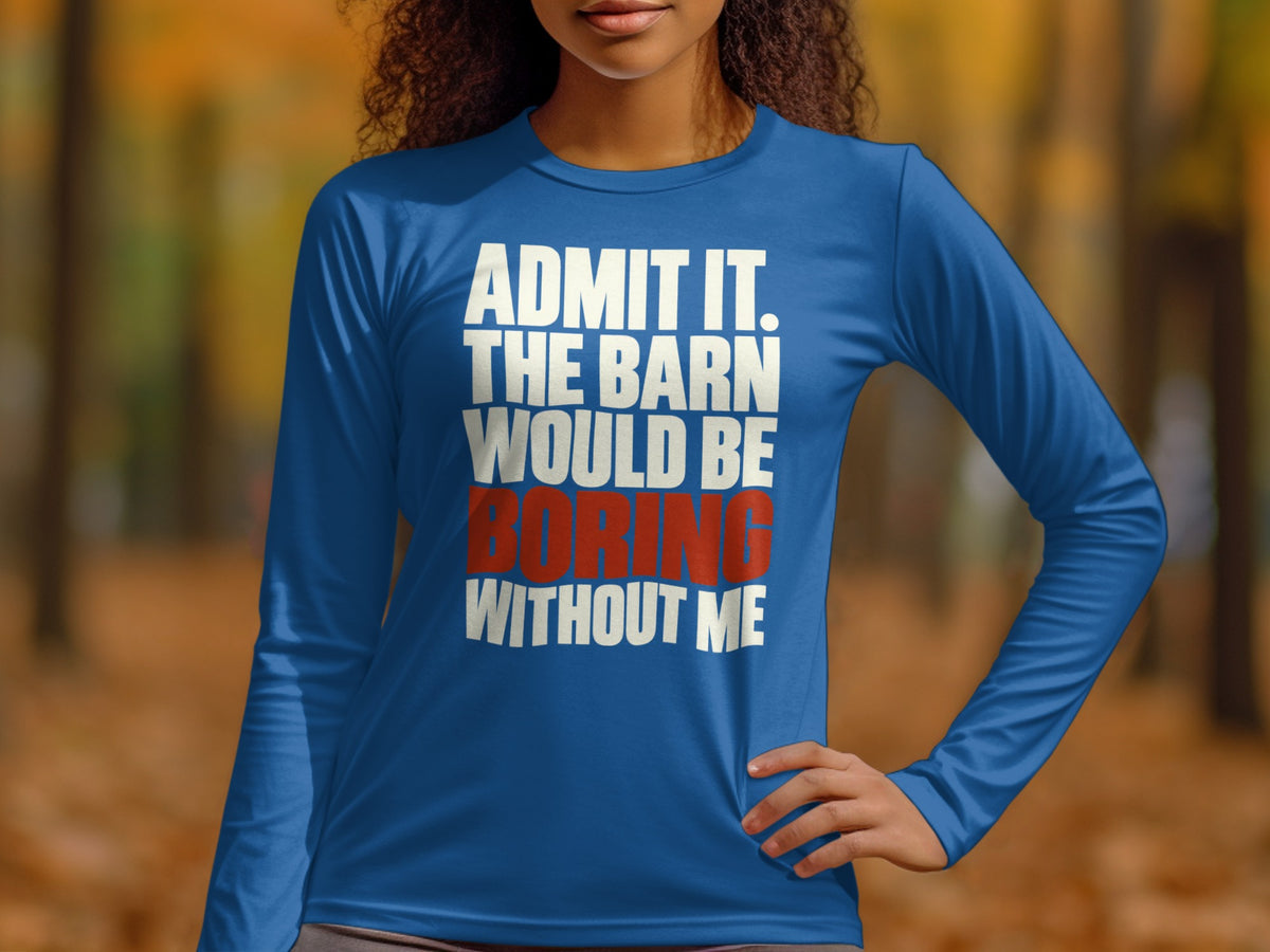 A woman wearing a blue long-sleeve shirt with white and red text stating, "Admit it, the barn would be boring without me."