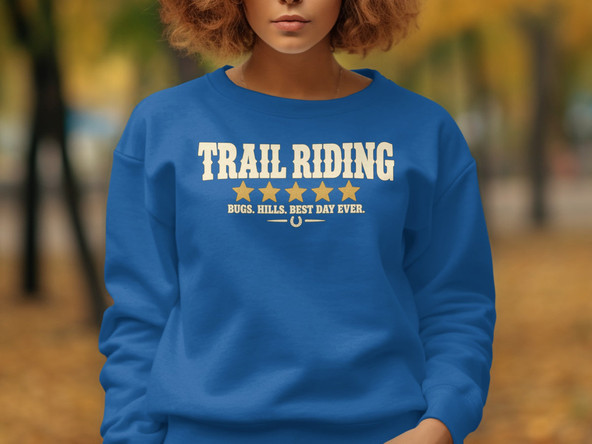 Blue sweatshirt with "TRAIL RIDING" text, five stars, and "BUGS. HILLS. BEST DAY EVER."