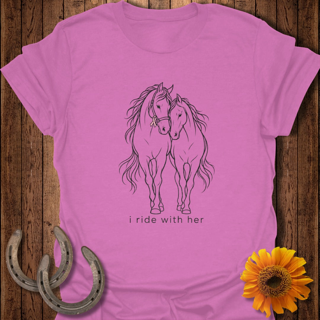 Pink t-shirt with black line drawing of two horses and "i ride with her" text.