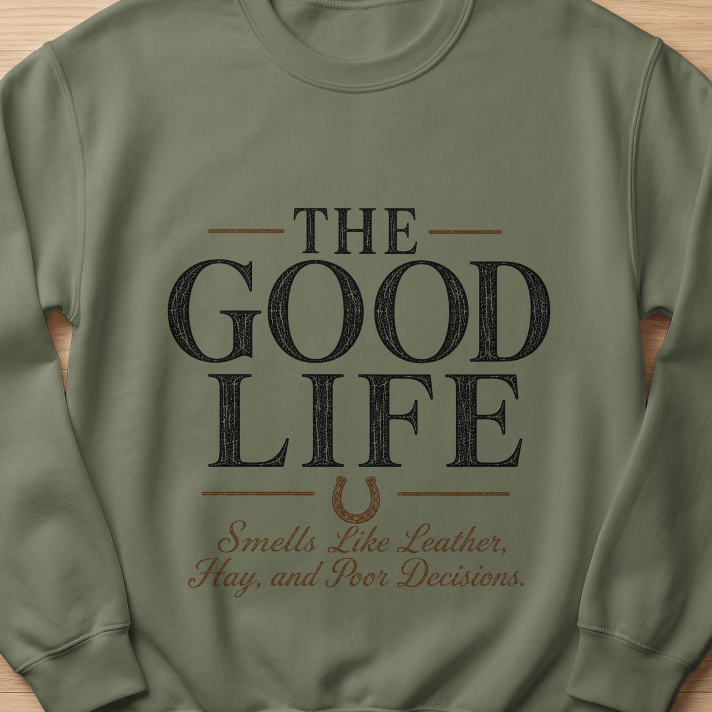 Green sweatshirt with "The Good Life Smells Like Leather, Hay, and Poor Decisions" graphic.