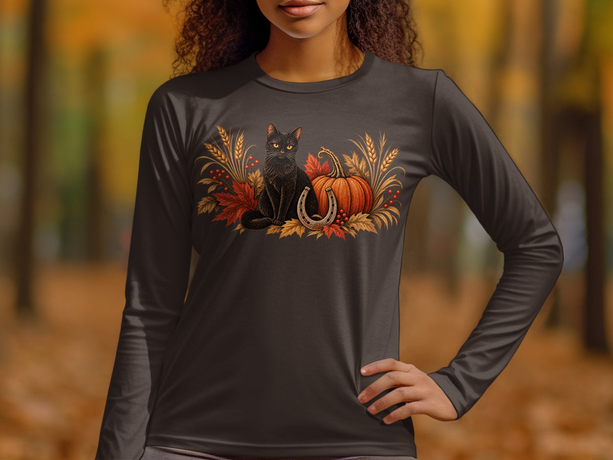 Black cat with pumpkin, horseshoe, and autumn leaves graphic on dark long sleeve shirt.