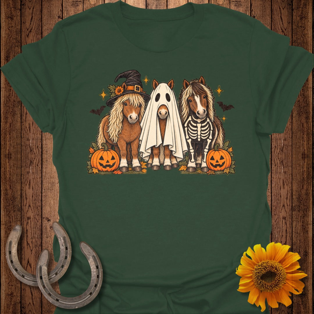 Three ponies, dressed as a witch, ghost, and skeleton, with pumpkins and bats.
