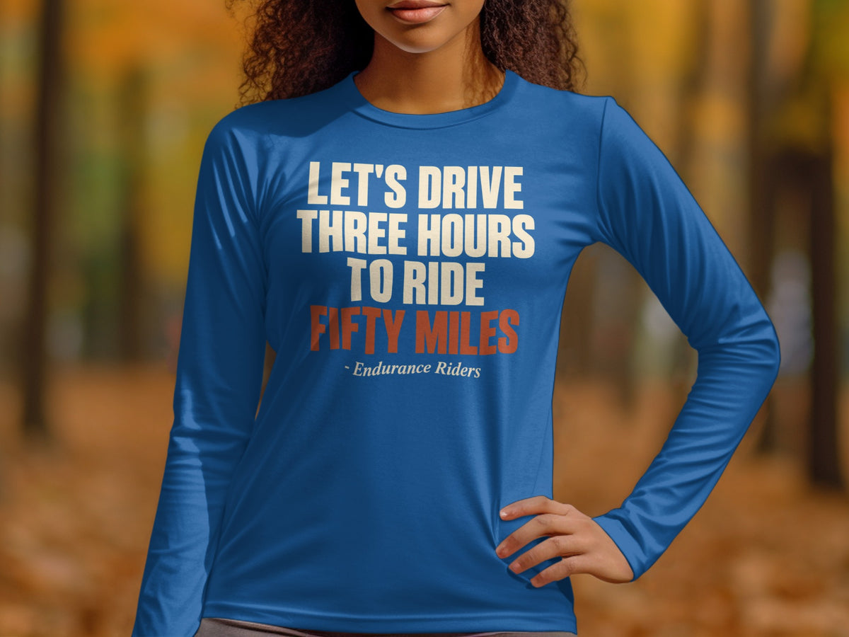 A person wears a blue long-sleeve shirt with white and orange text that reads, Let's drive three hours to ride fifty miles.