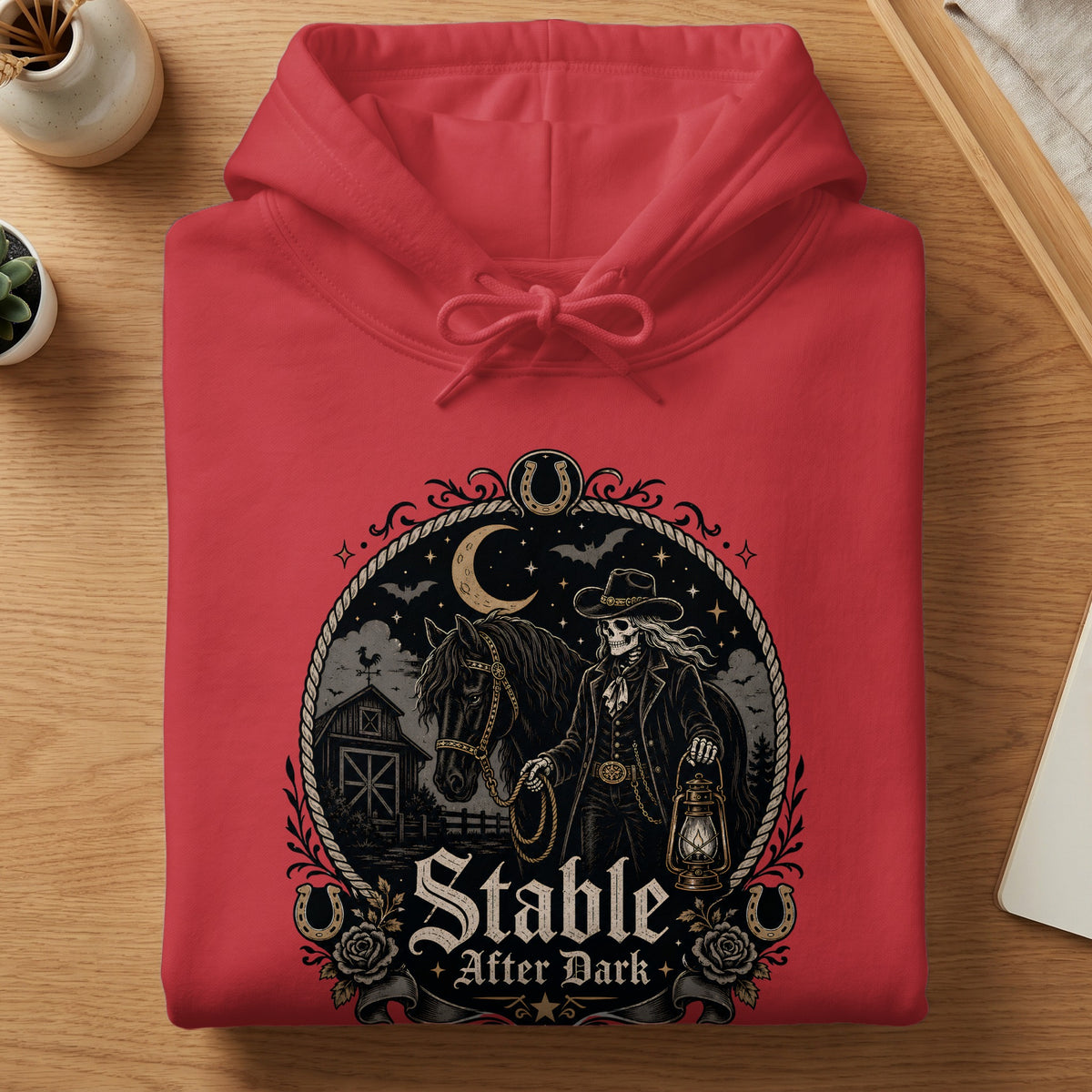 Red hoodie featuring a "Stable After Dark" graphic with a skeleton cowboy, horse, and barn.