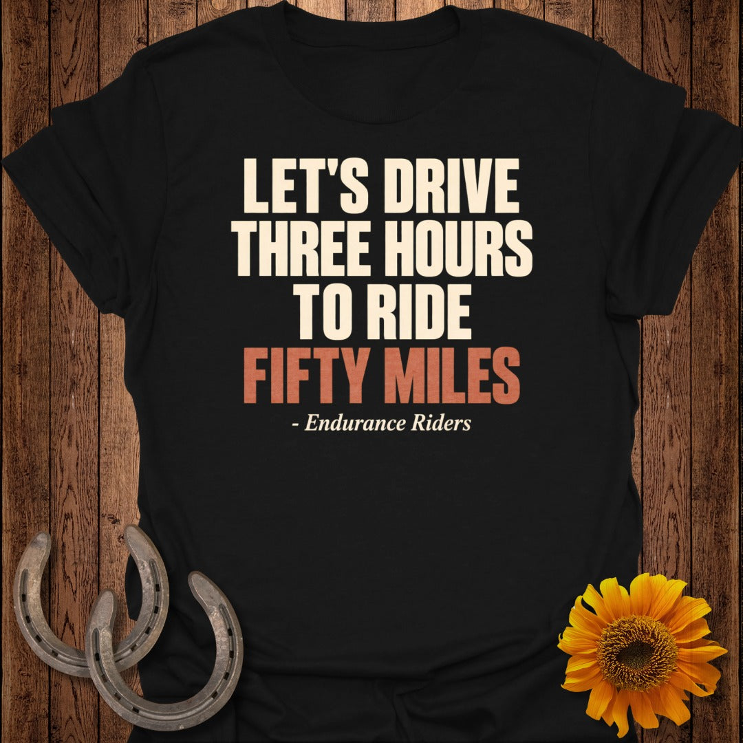Black t-shirt with white text: "LET'S DRIVE THREE HOURS TO RIDE FIFTY MILES"