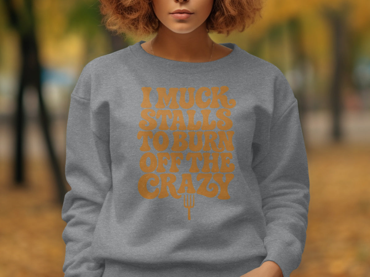 Grey crewneck sweatshirt with orange text "I MUCK STALLS TO BURN OFF THE CRAZY".