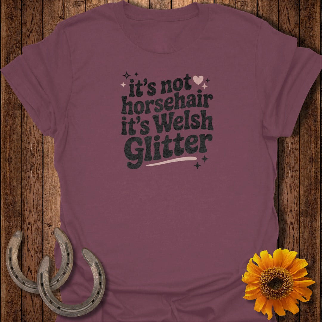 Maroon t-shirt with "it's not horsehair it's Welsh Glitter" text and horseshoe accents.