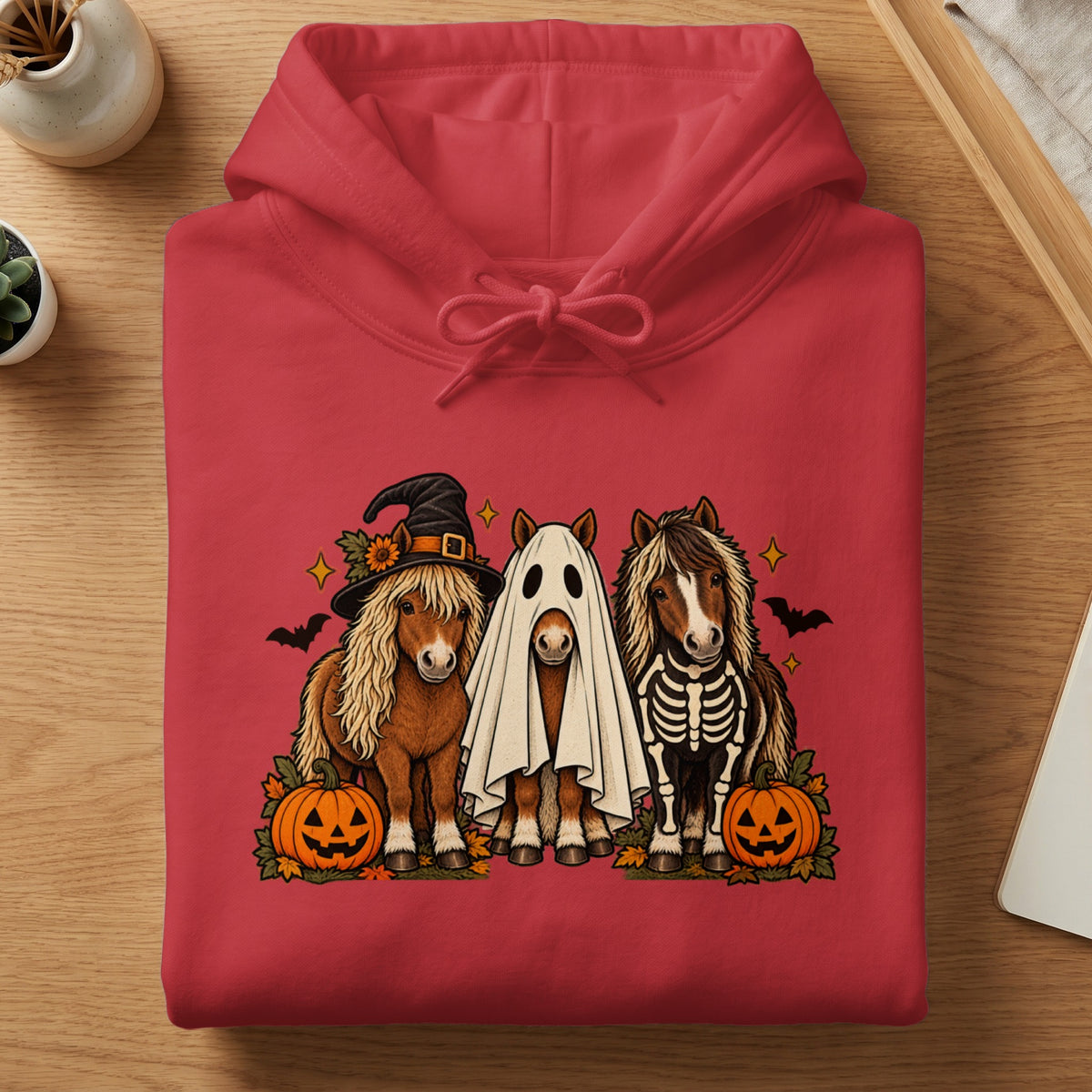 Three horses in Halloween costumes, including witch, ghost, and skeleton, with pumpkins.