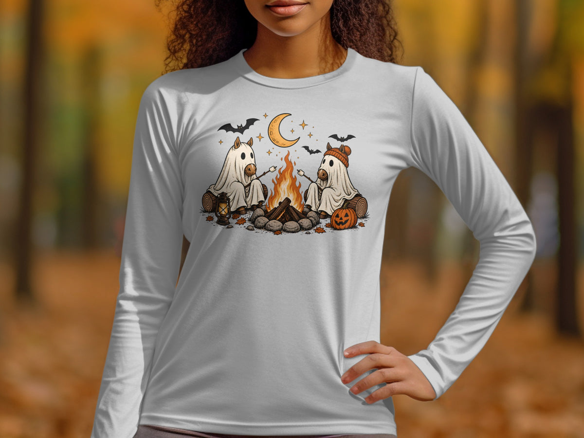Two horses in ghost costumes roast marshmallows by a campfire under a crescent moon.