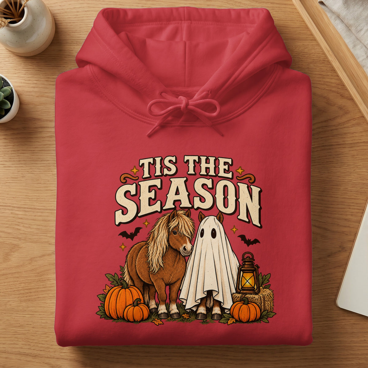 Red hoodie with "Tis the Season" text and Halloween-themed horses, pumpkins, and a ghost.