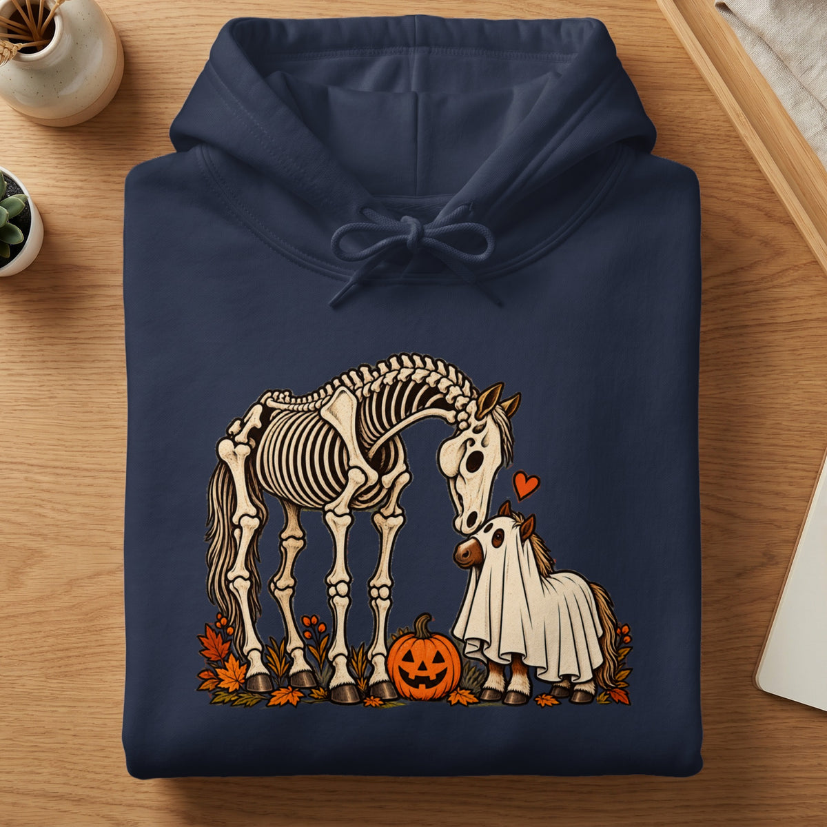Skeleton and ghost horses with a pumpkin and autumn leaves on a navy hoodie.