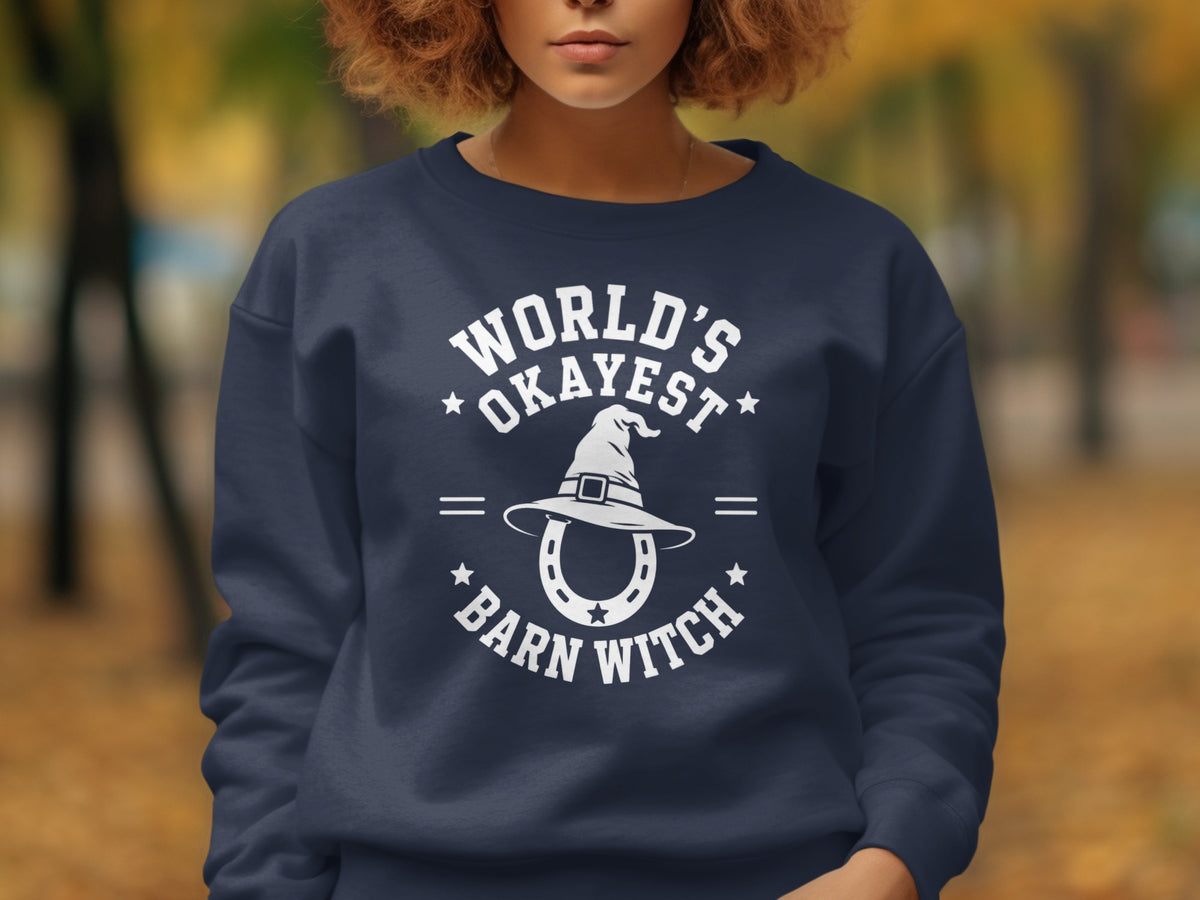 Navy sweatshirt with white text and graphics reading "World's Okayest Barn Witch" and a horseshoe.