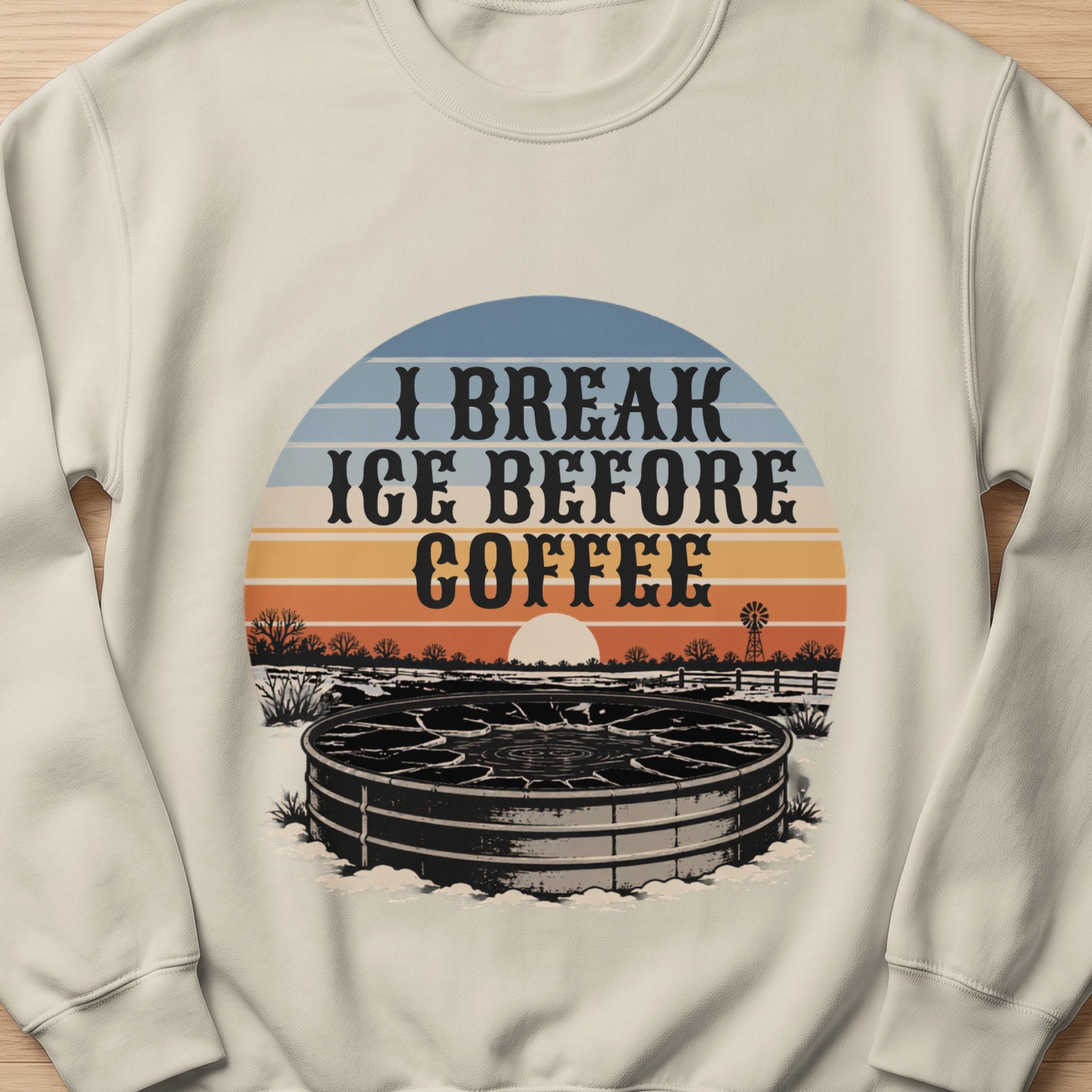 Cream sweatshirt with "I Break Ice Before Coffee" text and winter livestock watering tank graphic.