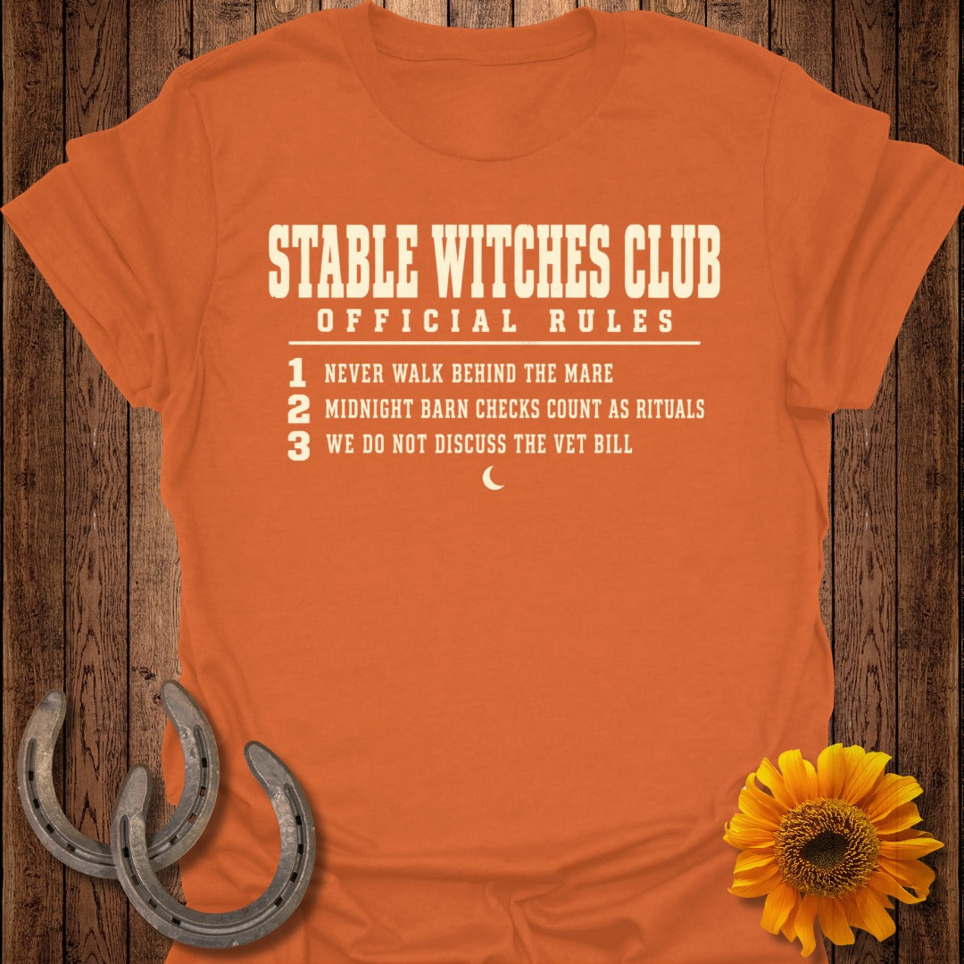 Orange t-shirt with "Stable Witches Club Official Rules" and three numbered rules.