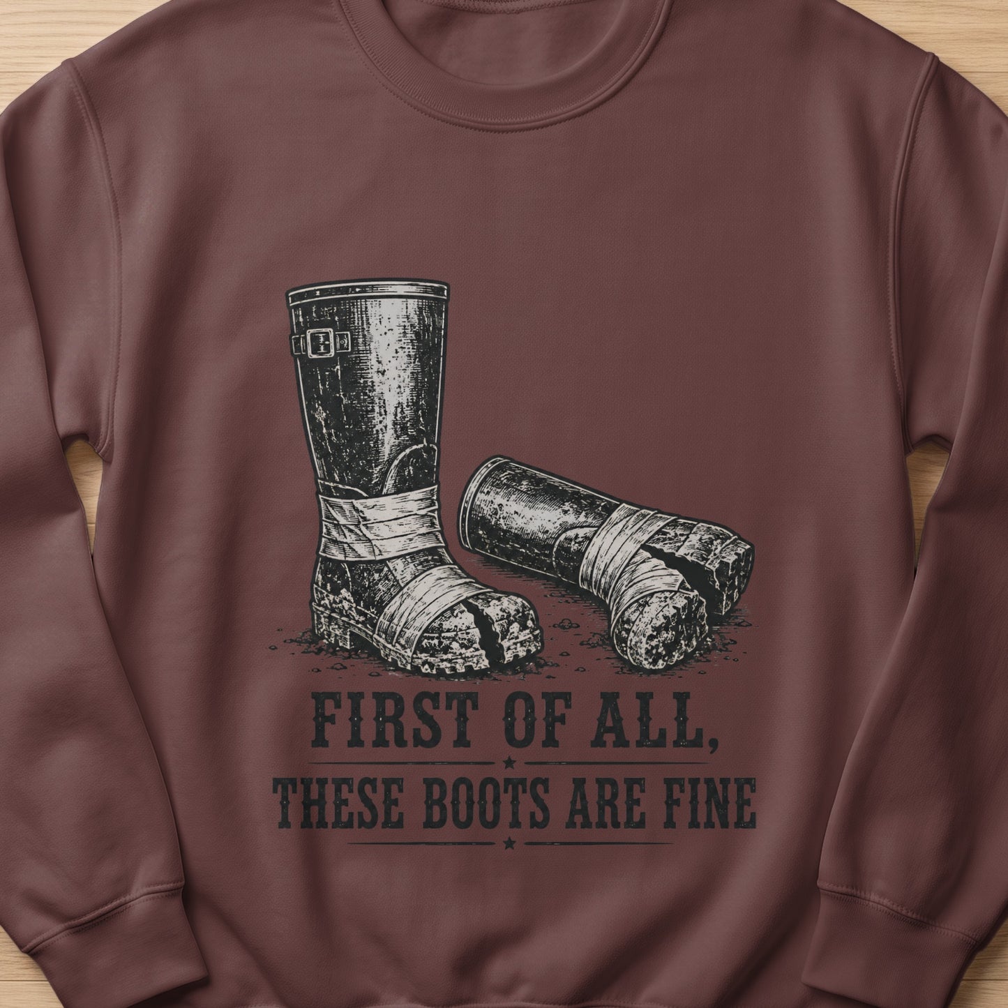 Brown sweatshirt with graphic of two worn boots and text "FIRST OF ALL, THESE BOOTS ARE FINE".