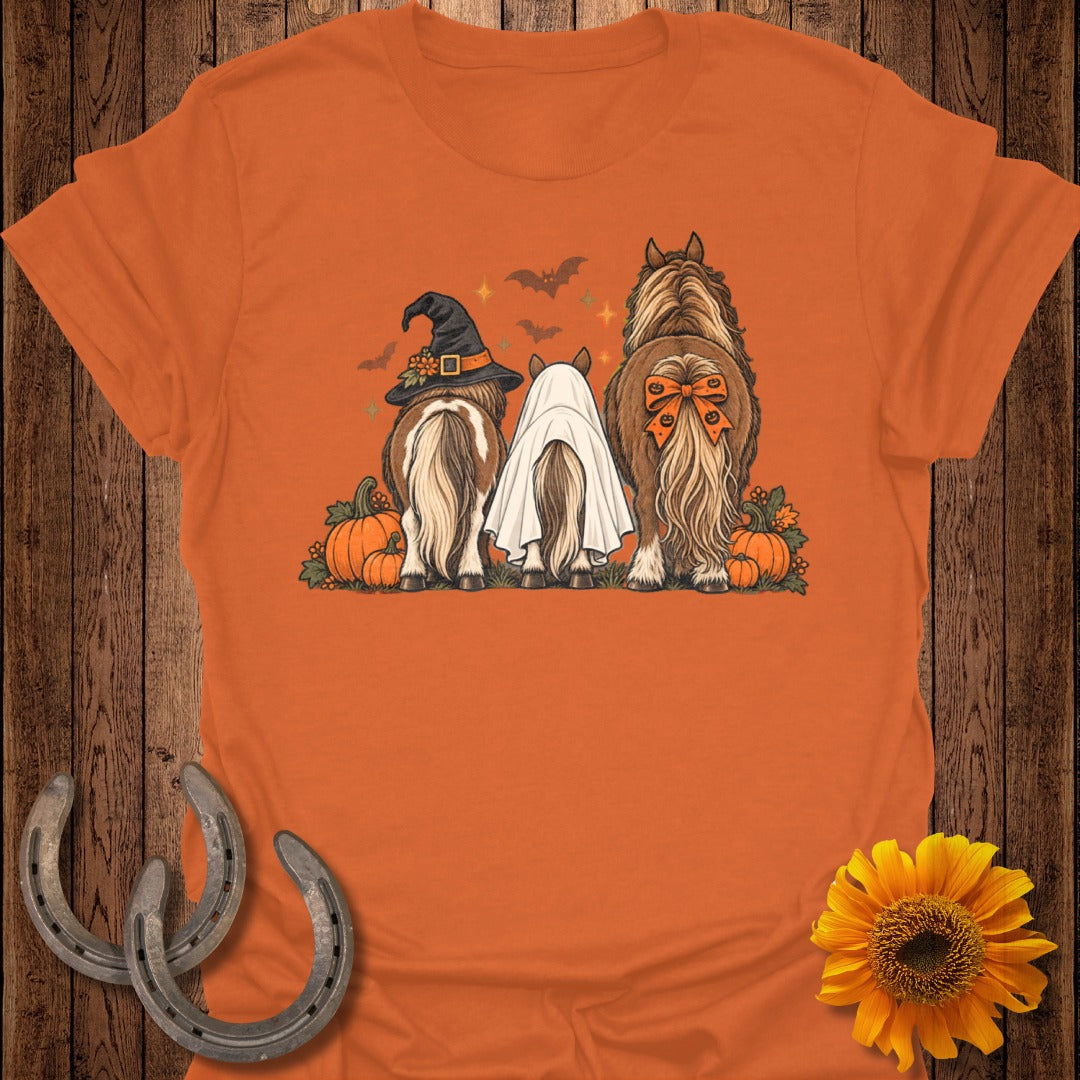 Three horses decorated for Halloween with pumpkins, bats, and witch hat and ghost costume.